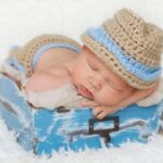 Bebé con gorro durmiendo en caja azul