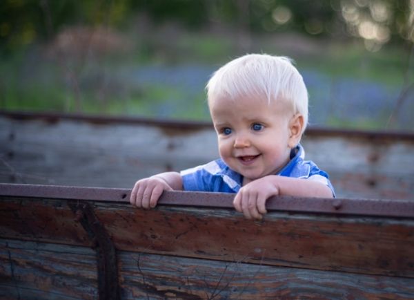 Niño sonriente sentado en un banco Niño rubio sentado en un banco y sonriendo