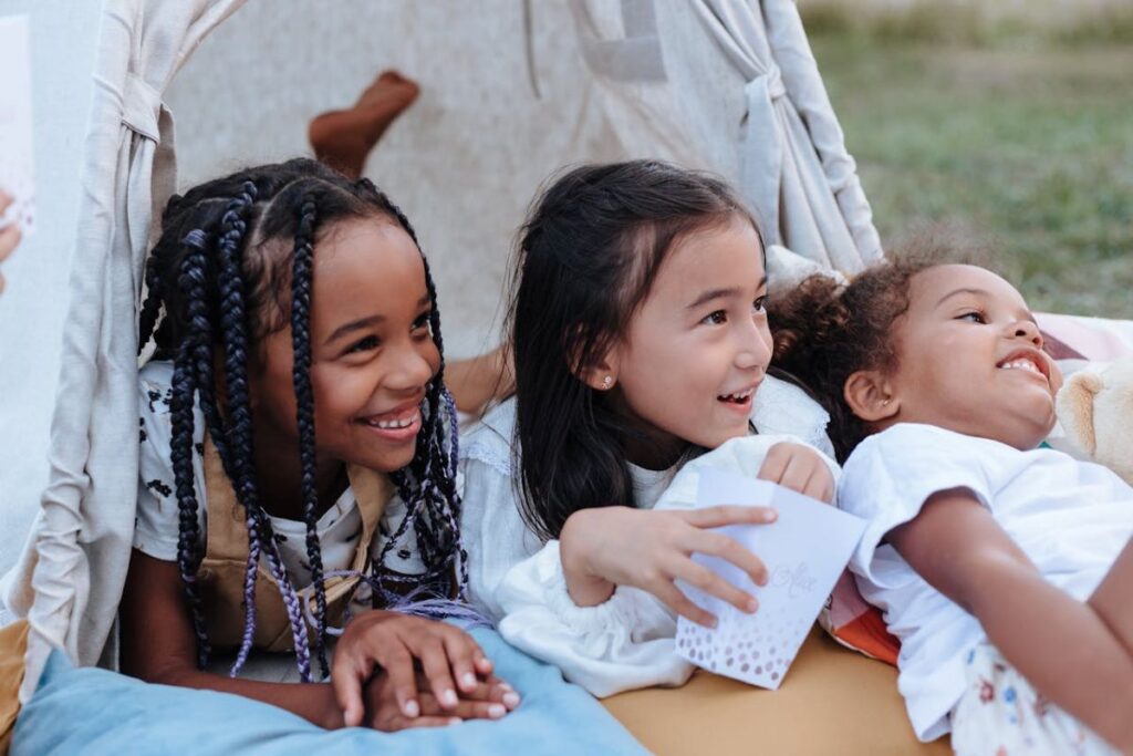 Tres niñas felices tumbadas en un tipi