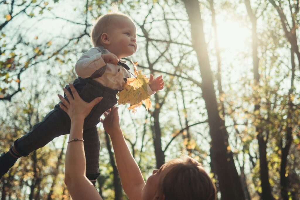Madre cogiendo a su hijo en un paisaje otoñal