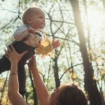 Madre cogiendo a su hijo en un paisaje otoñal