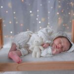 Bebé durmiendo en cama de madera