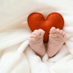 Pies de bebé con corazón rojo como imagen principal del artículo de nombres de niña que significan amor